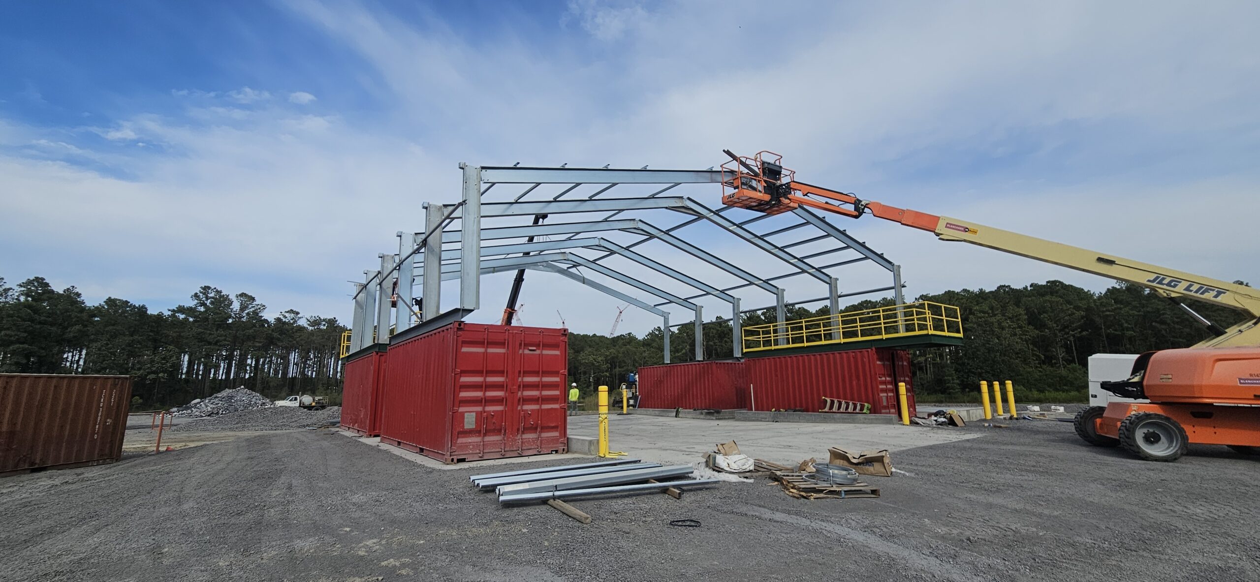 Connex-Based Equipment Shelter & Steel Superstructure Installation Steel building framework installed over shipping container connex boxes using manlifts and telehandler at an industrial site in Charleston, South Carolina