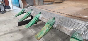 Beveled cutting edge with new ESCO tooth adapters welded and aligned during dragline bucket rebuild